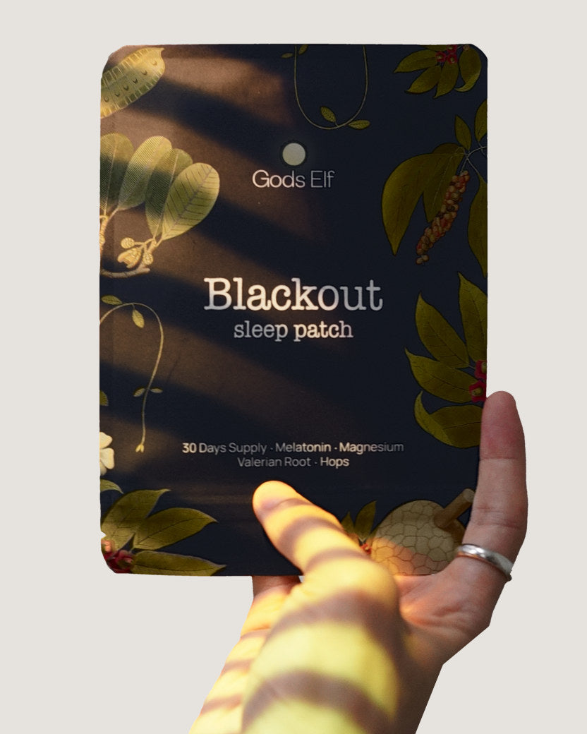 The Blackout pouch held up in evening light, a patch on the wrist below it